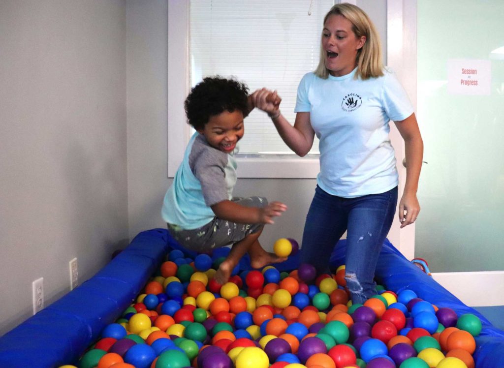 Young boy in ballpit with staff member of CTC