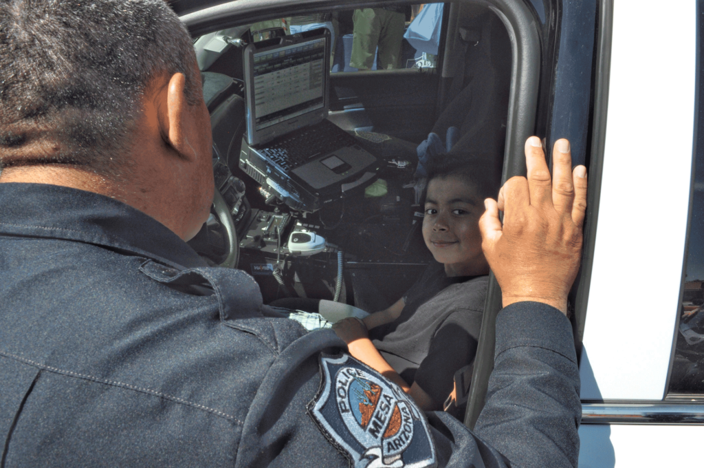 Young boy in front seat of Mesa PS cop car