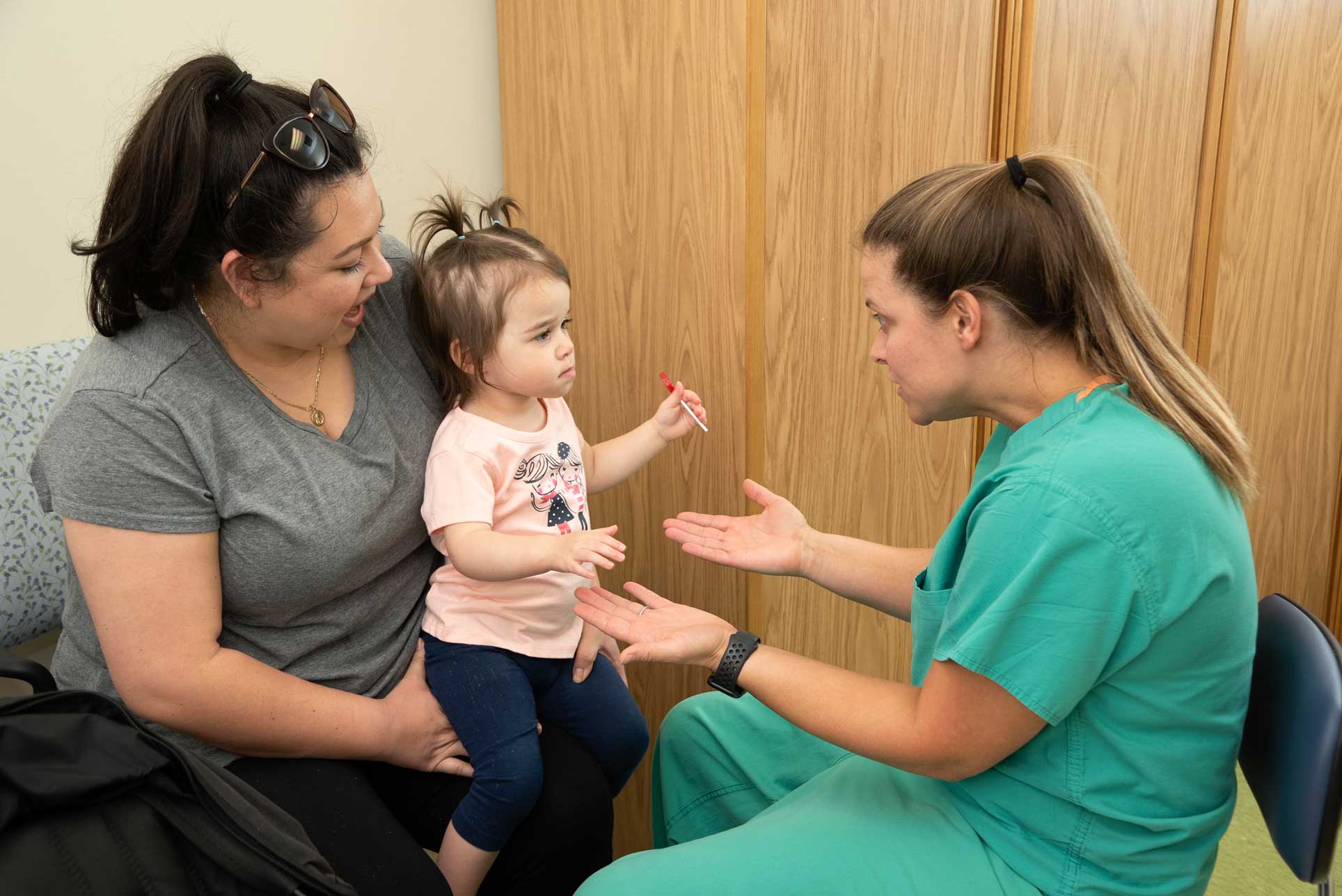 St. Tammany Health System Bone and Joint Clinic staff member helping family with young girl