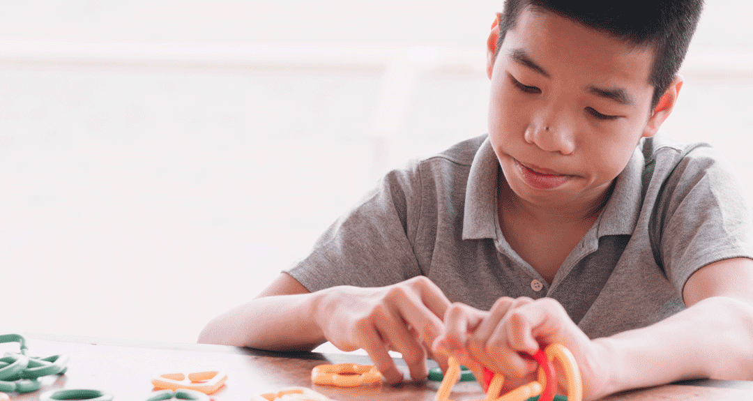 Asian boy working on fine motor skills