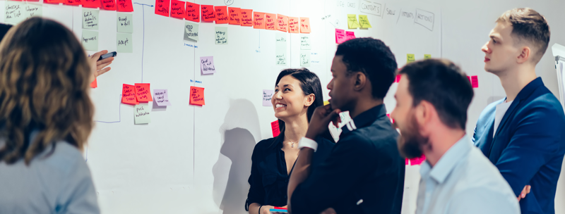 diverse staff working together at whiteboard