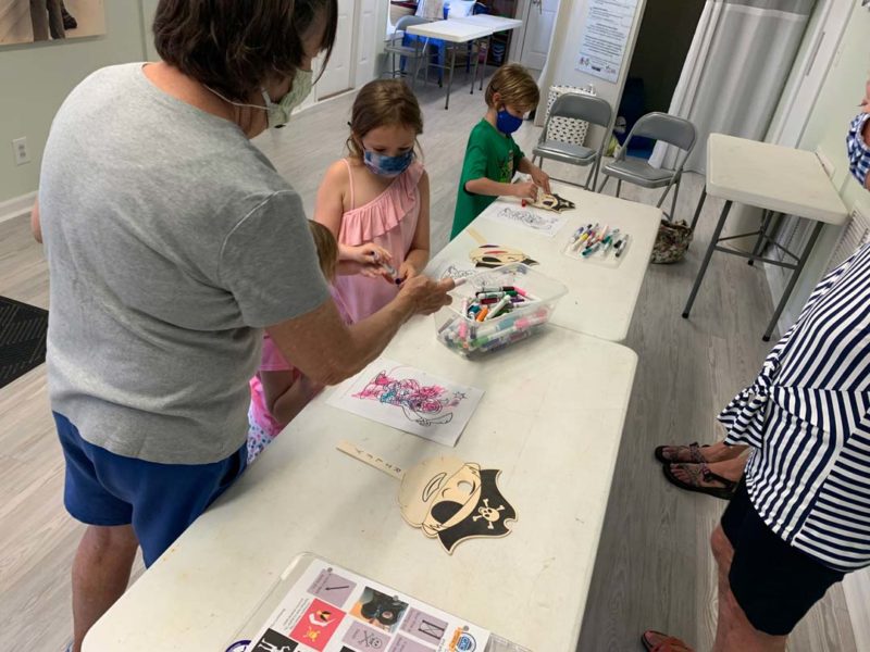 North Carolina Maritime Museum at Southport summer camp volunteers helping campers with coloring activity