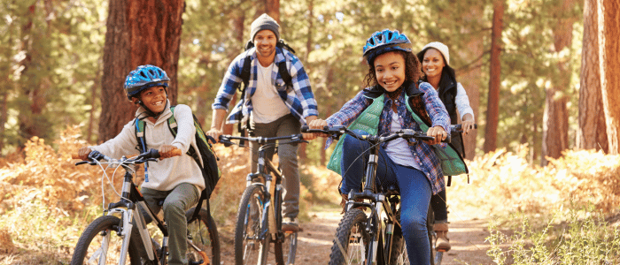 A family of four biking in a park.